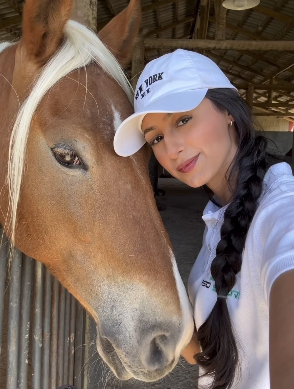 Gabriela Chagas ao lado de um cavalo alazão de crina clara