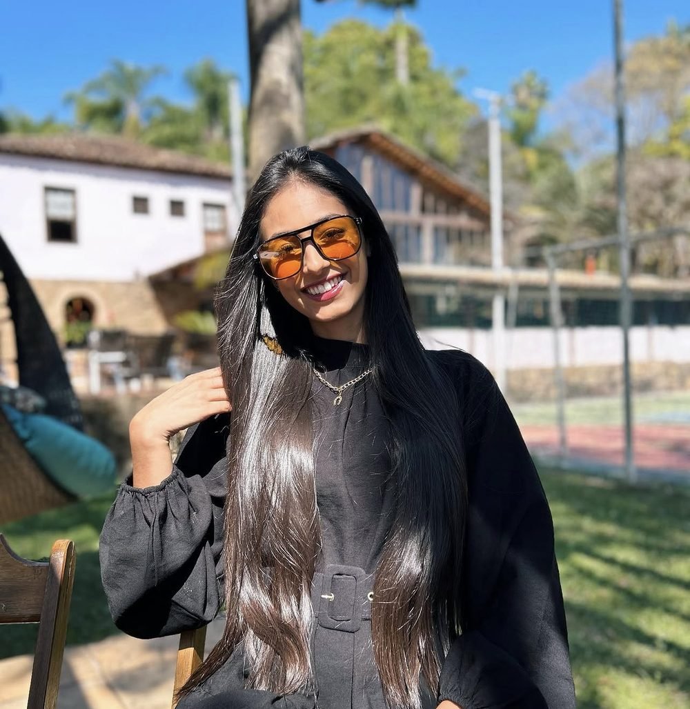 Gabriela Chagas sorrindo, sentada ao ar livre